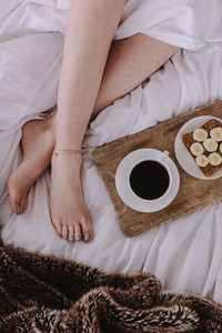 Top view of a woman in bed with breakfast