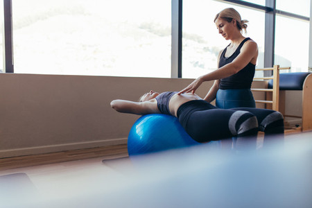 Woman training on exercise ball in a pilates training gym