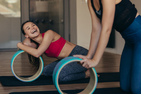 Pilates women at a gym holding a yoga or pilates wheel