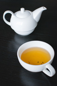 Cup of green tea and teapot