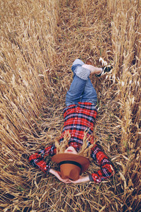 Young woman resting in a field of wheat