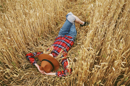 Young woman resting in a field of wheat