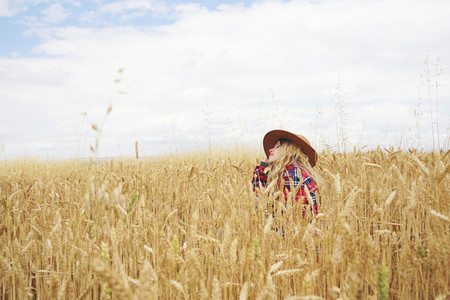 Young country woman in a field of wheat