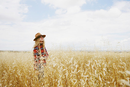 Young country woman in a field of wheat