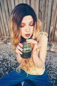 Blonde woman drinking a smoothie