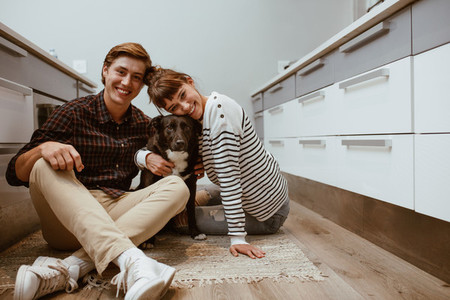 Happy couple at home with pet dog