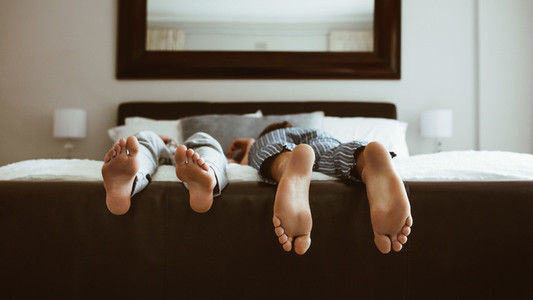 Close up of feet of couple sleeping on bed