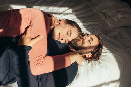 Couple sleeping on bed together