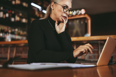 Beautiful senior freelancer woman using laptop at cafe