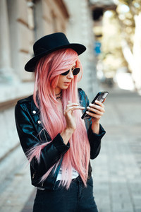 girl with pink hair with a smartphone