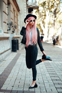 girl with pink hair posing on city street