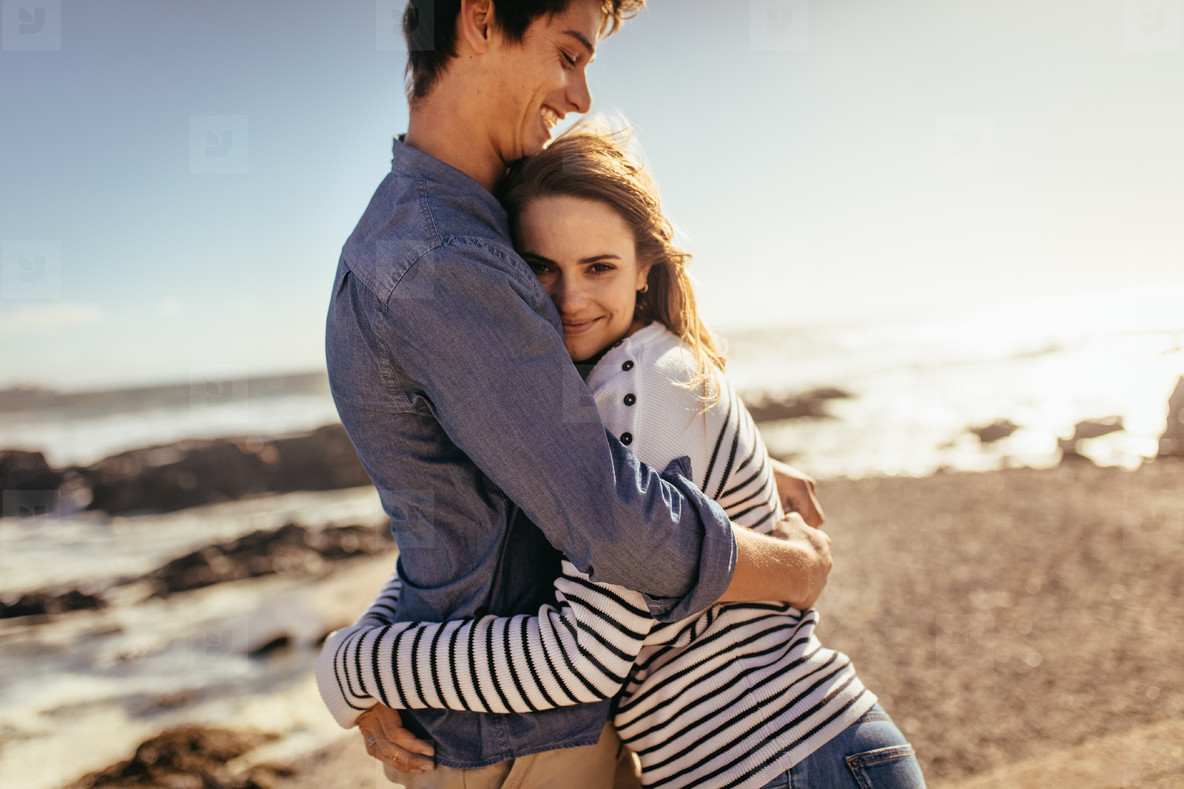 Loving Retired Couple Hugging Standing By Shore On Winter 