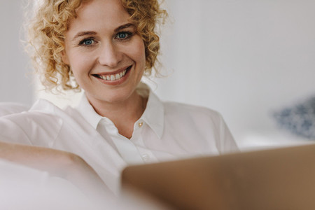 Close up of a smiling woman with a laptop