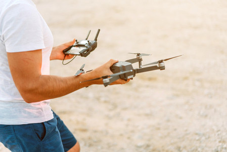 Young man holding drone before flight at nature