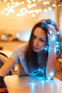 Woman holding glowing christmas garland in hands