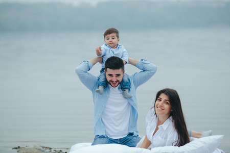 Happy young family relaxing together on the lake