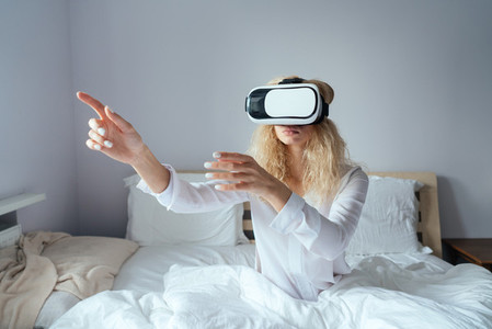 Girl sitting on a bed with VR headset