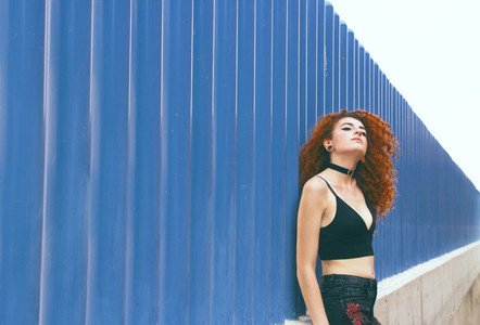 Redhead woman against blue wall