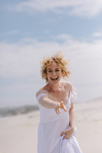 Portrait of a smiling woman standing on the beach