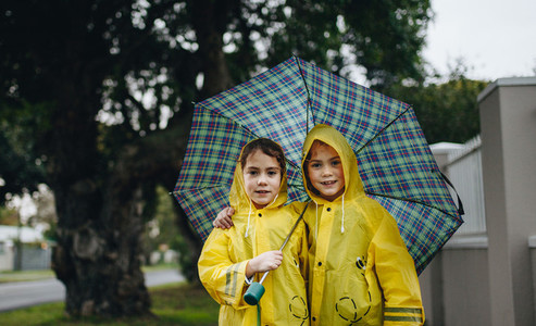 Beautiful sisters under an umbrella outdoors