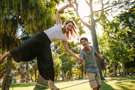 Woman practices slacklining in a park