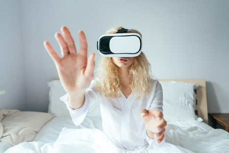 Girl sitting on a bed with VR headset