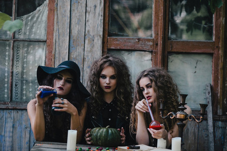 Three vintage witches perform magic ritual