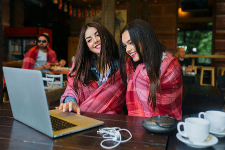 two girls watching something in laptop