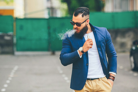 well dressed man smoking electronic cigarette
