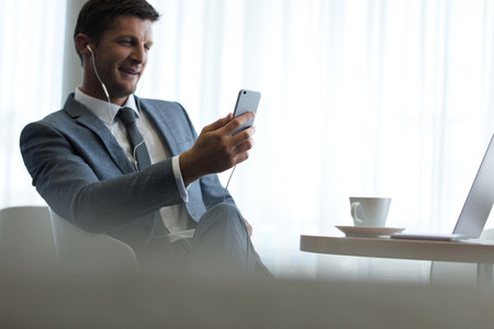 Businessman with smartphone having video call