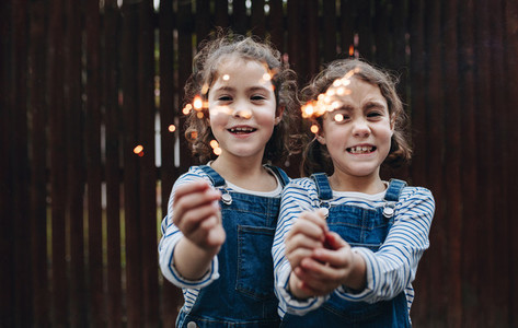 Little girls holding sparklers outdoors