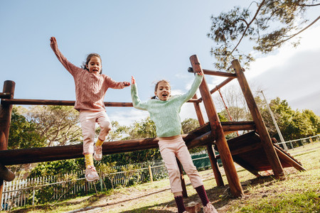 Happy little girls playing at outdoor playground