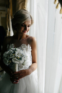 beautiful bride in a wedding dress by window