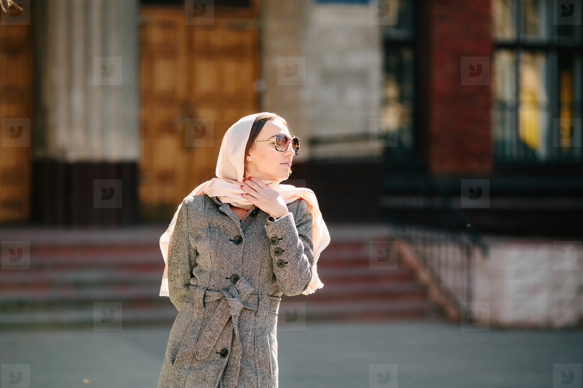 girl in a coat posing on building background