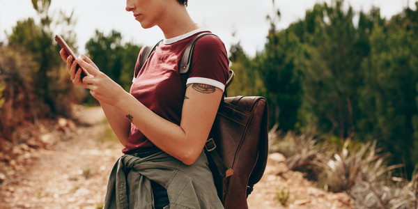Woman hiker checking her mobile phone
