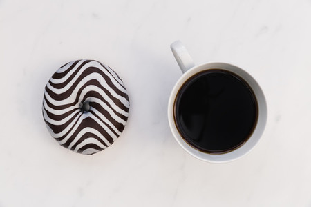 Striped donut and coffee cup white background