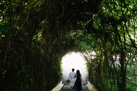 couple walking through the tunnel of trees