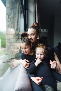 Mom and two daughters together at the window