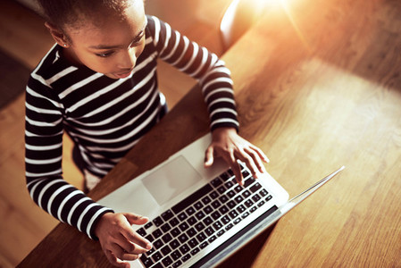 Young ethnic black girl typing on a laptop