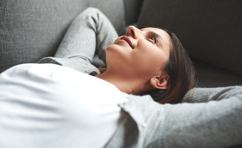 Woman laying on back resting on couch