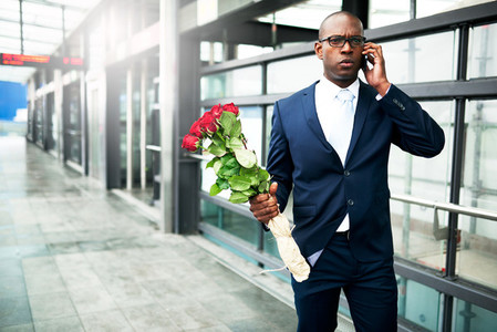 Businessman with Flowers Calling on his Phone
