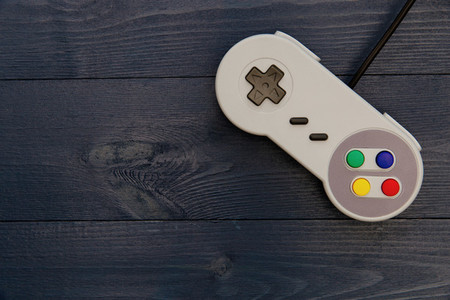 Retro video game controller on dark table background