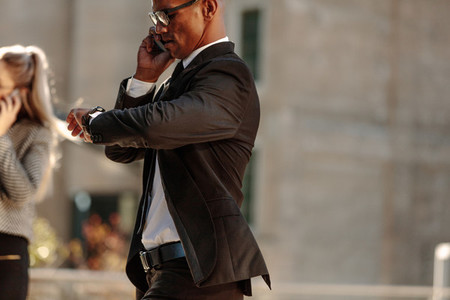 Businessman checking time while going to office