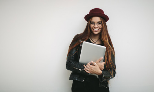 Portrait of a smiling businesswoman holding a laptop