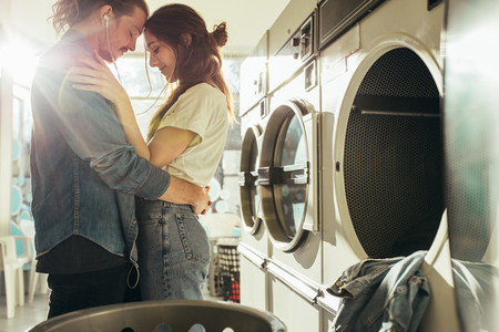 Intimate couple standing in laundry room