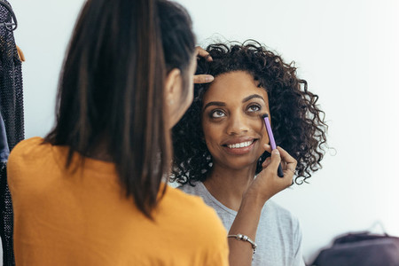 makeup artist applying makeup under the eye of a model
