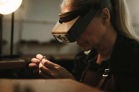 Senior jeweler examining a ring with magnifying glass