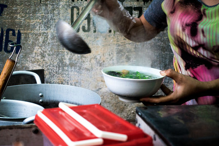 Woman pouring soup in a bowl
