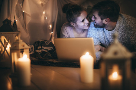 Romantic couple on bed with a laptop