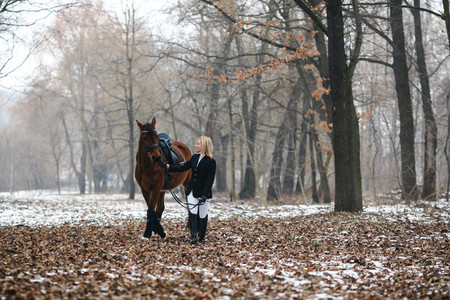 Young woman with horse in snow